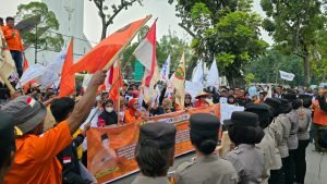 Massa Partai Buruh memberikan bunga kepada polisi saat aksi damai May Day 2026 di depan Kantor Gubernur Sumatera Utara di Medan