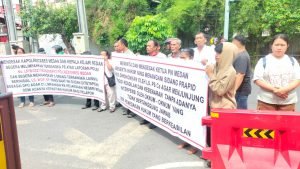 Sejumlah massa aksi membawa spanduk di depan Polrestabes Medan menuntut penangkapan tersangka penganiayaan yang masuk DPO.